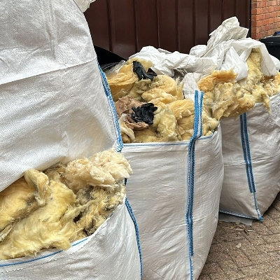 four rubble sacks filled to the top with old floor insulation